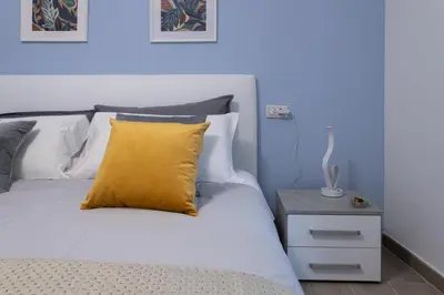 a bed with a yellow pillow and a night stand at Vigna Clara apartment in Rome