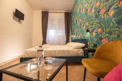 a small hotel room with a bed and a painting at RHome 34 in Rome