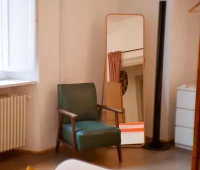 a green chair sitting in front of a mirror at Pop Apartment in the Heart of Trastevere 4 Guests in Rome