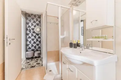 a white bathroom with a sink and a shower at Asinari Retreat in Rome