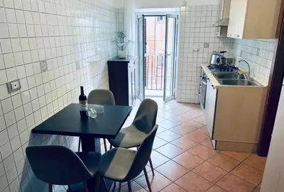a kitchen with a table and chairs and a sink at Casa di Andrea in Trastevere in Rome