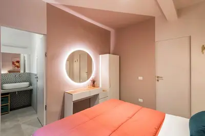 a bedroom with an orange bed and a mirror at GF Harmony Suite Colosseo in Rome