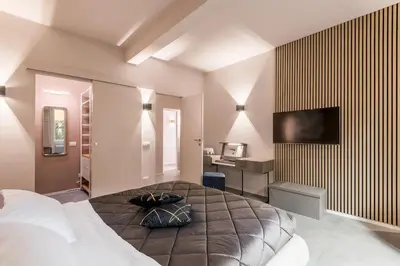 a bedroom with a bed and a desk and a television at GF Harmony Suite Colosseo in Rome