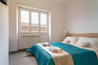 a bedroom with a large bed with towels on it at Saulo Boutique Apartment in Rome