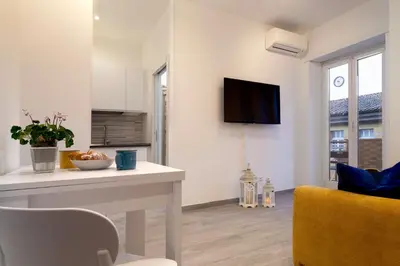 a living room with a table and a tv on a wall at Saulo Boutique Apartment in Rome