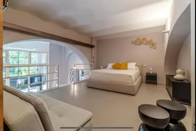 a bedroom with a bed and a couch and a balcony at Margutta Spagna Relais in Rome