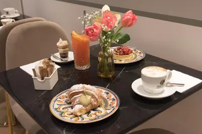 a table with two plates of food and a cup of coffee at Colosseum suites by Glen in Rome