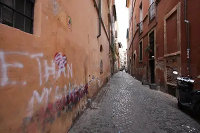 an alley with graffiti on the side of a building at Navona Large 1BR Holiday House in Rome