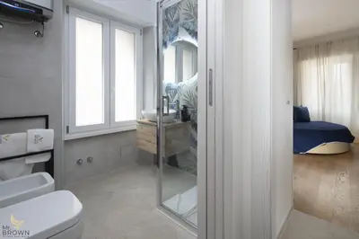 a bathroom with a toilet and a mirror at MrBrown - Dimora Lucrezia al Vaticano in Rome