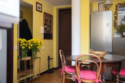a dining room with a table and chairs and yellow walls at Oasi Tiberina in Rome