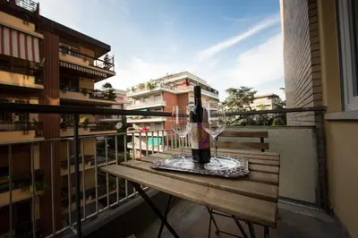 a wine glass and bottle on a table on a balcony at B&B Roma 474 in Rome