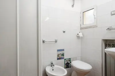 a white bathroom with a toilet and a sink at Studio House da Pasolini a Mastroianni in Rome