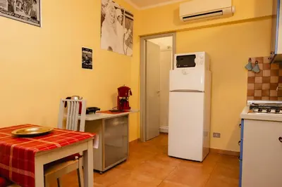 a kitchen with a white refrigerator and a table at Studio House da Pasolini a Mastroianni in Rome