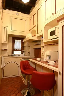 a kitchen with white cabinets and red bar stools at Casa dell'Opera LUXURY STAY in Rome