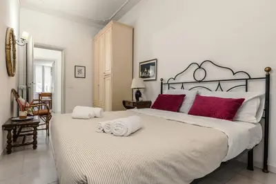 a bedroom with a bed with pink pillows and a mirror at Ottaviano Vatican Museums Stay 5 min from Metro in Rome