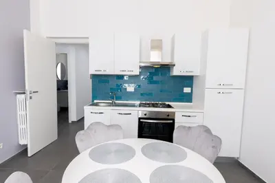 a kitchen with white cabinets and a white table and chairs at Travel House in Rome