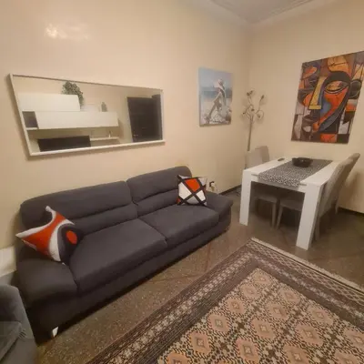a living room with a couch and a table at Red Moon House - tra Policlinico e Piazza Bologna in Rome