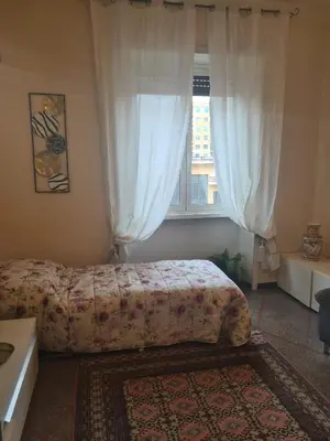 a bedroom with a bed and a window with curtains at Red Moon House - tra Policlinico e Piazza Bologna in Rome