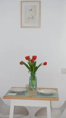 a vase of red roses sitting on a table at Augusto's House b&b in Rome