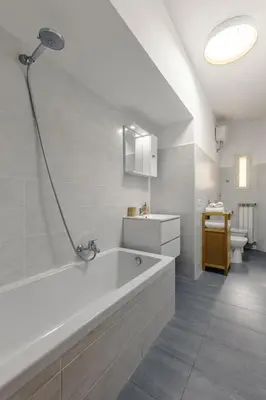 a white bathroom with a tub and a toilet at Macro House in Rome