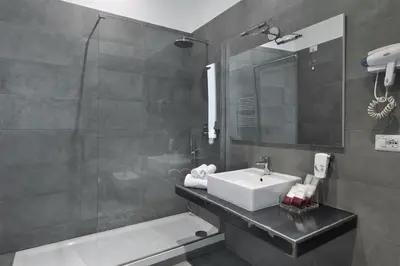 a bathroom with a sink and a shower at DA ME Suites in Rome