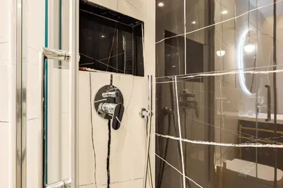 a shower with a blow dryer hanging from a wall at Vatican 10 min Modern apartment AC, Wi-Fi, Netflix in Rome