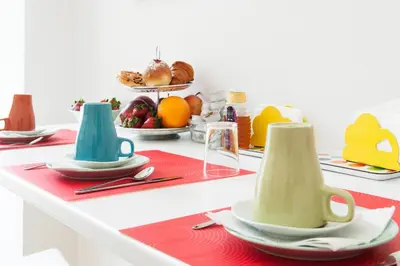 a table with plates and cups on a table with food at Rome Center Rooms in Rome
