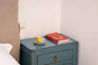 a bedside table with a cup of coffee and a book at Amazing Piazza Fiume in Rome