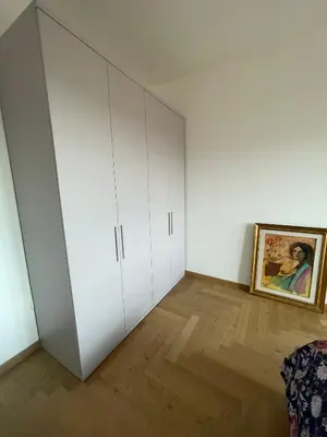 a room with white cabinets and a painting on the wall at la casa di Janis in Rome
