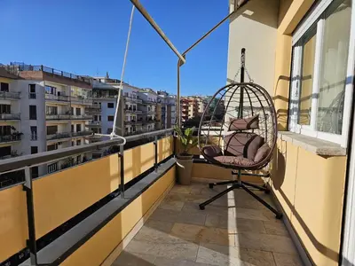 a chair on a balcony with a view of buildings at Upper San Pietro elegant flat on metro A with a view in Rome