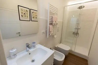 a white bathroom with a sink and a toilet at 2-Bedroom Roman Gem in Rome