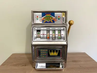 a metal slot machine sitting on top of a wooden table at Triade Home in Rome