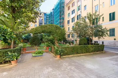 a courtyard with plants and trees and buildings at Dome At Home in Rome