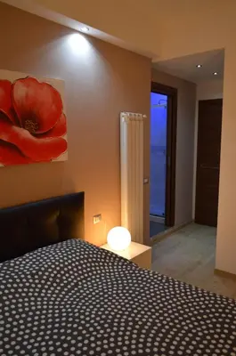 a bedroom with a red flower painting on the wall at Gloria Vatican Bijou in Rome