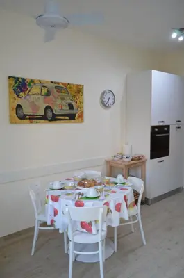 a dining room with a table and chairs and a kitchen at Gloria Vatican Bijou in Rome