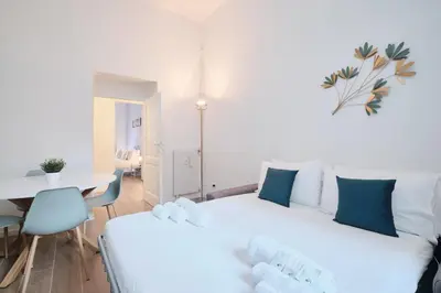 a bedroom with two white beds and a table at Vatican Museums - Modern flat with Wi-Fi & Netflix in Rome