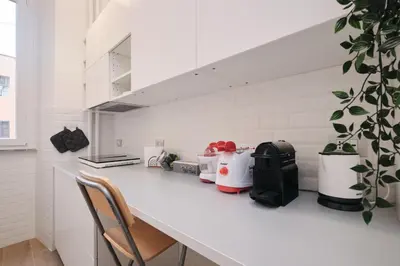 a white kitchen with a counter with pots and pans at Vatican Museums - Modern flat with Wi-Fi & Netflix in Rome