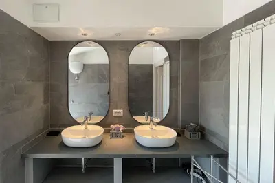 two sinks in a bathroom with two mirrors at Appartamento al Vaticano in Rome