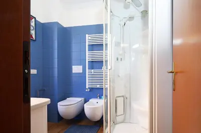 a blue bathroom with a toilet and a shower at Stella House in Rome