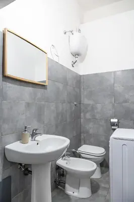 a bathroom with a sink and a toilet and a mirror at Lion Renting Vatican Apartment in Rome