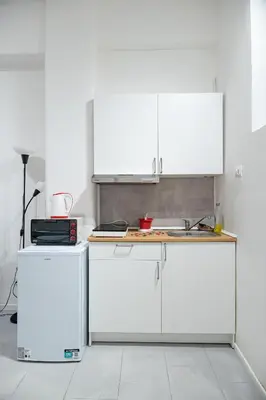 a kitchen with white cabinets and a counter at Lion Renting Vatican Apartment in Rome