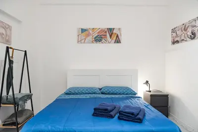 a bedroom with a blue bed with two towels on it at Lion Renting Vatican Apartment in Rome