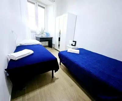 a bedroom with two beds with blue sheets and a window at BFabretti5 in Rome