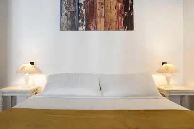 a bedroom with a bed with two lamps on two tables at Exclusive House Ghetto in Rome