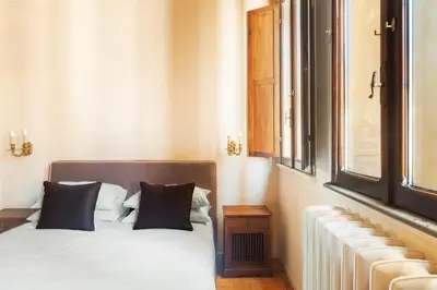 a bedroom with a bed with black pillows and a window at Casa Maestro, a Burghesius home in Rome