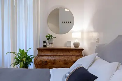 a bedroom with a bed and a mirror on a table at Kenzia Suite Aventino in Rome