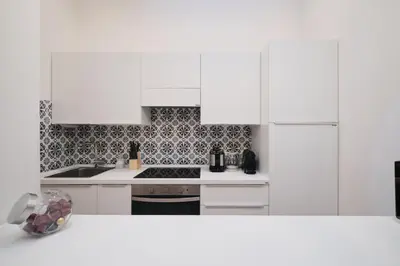 a white kitchen with a stove and white cabinets at Castel Sant'Angelo - Elegant flat in Rome Centre in Rome