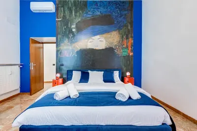 a bedroom with a large bed with a painting on the wall at BDC - Galatea Art Gallery 3BDR at Testaccio in Rome