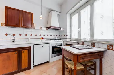 a kitchen with white appliances and a wooden table at Rossini Home in Rome