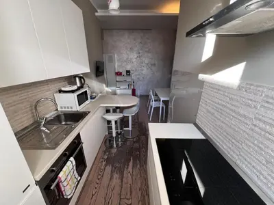 a small kitchen with white cabinets and a sink at La Casa Di Piero in Via Ottaviano in Rome